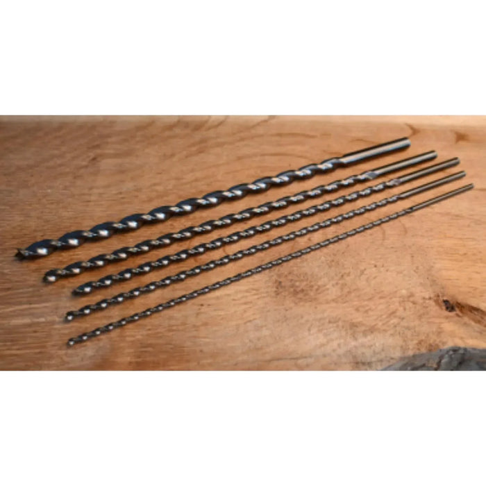 Set of drill bits of varying diameters on a wooden surface