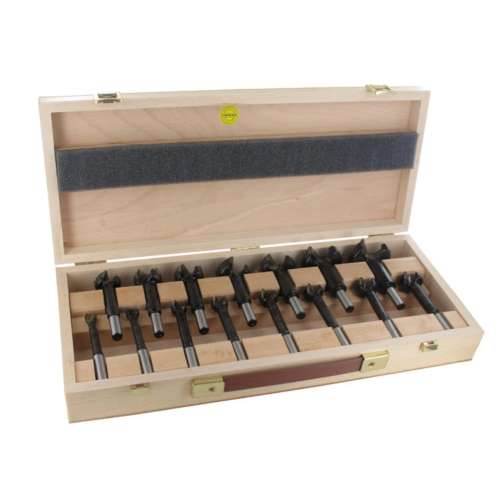 Set of 15 black forstner bits in a wooden box on a white background